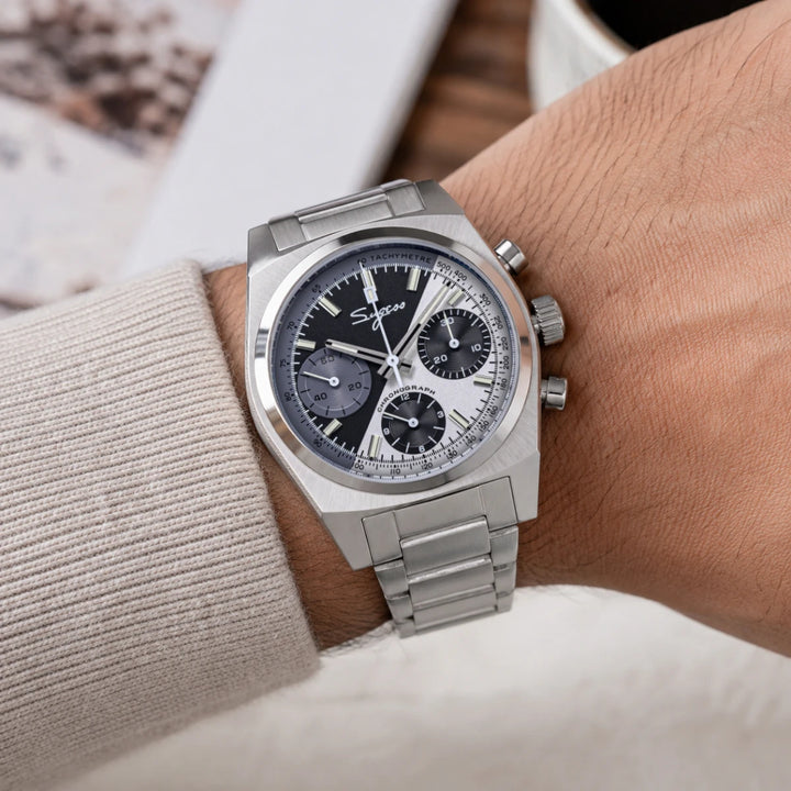 Silver chronograph watch on wrist with metal bracelet and dark dial