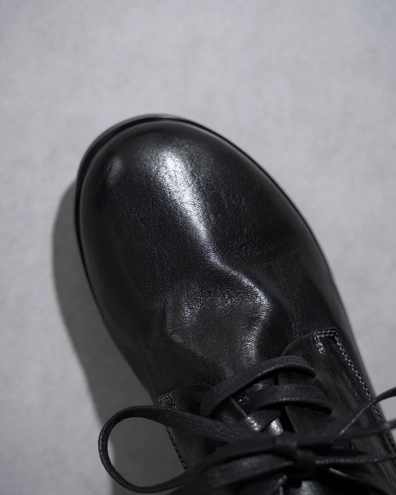 Black leather lace-up flat shoe toe and laces close-up