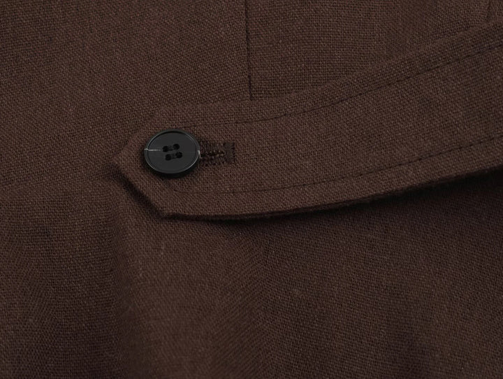 Dark brown coat chest seam with small button detail on the placket