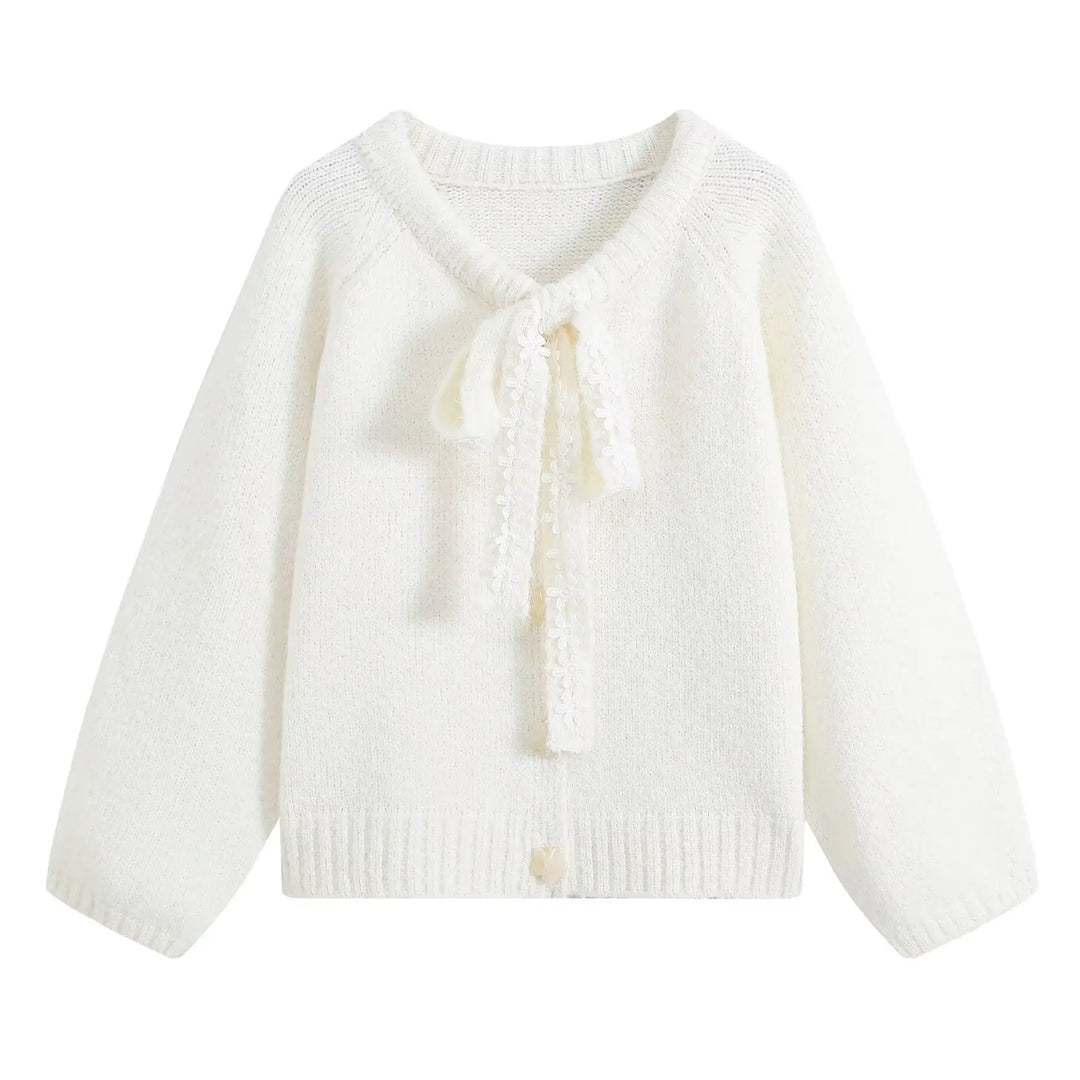 White cropped knit cardigan with tied bow front and tassel accents