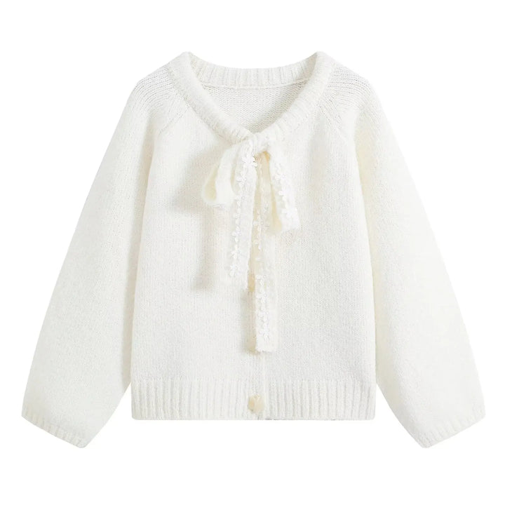 White cropped knit cardigan with tied bow front and tassel accents