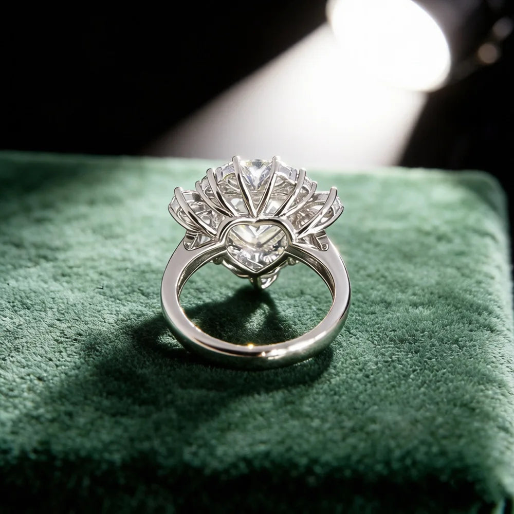 Sterling silver halo ring with round center stone, side view on soft green surface.