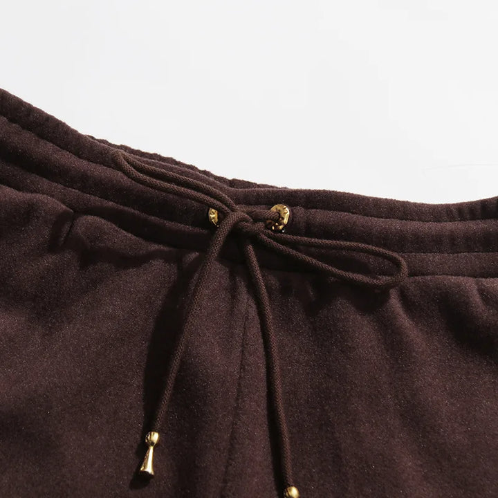 Coffee brown pants waistband close-up with drawstring and gold bead ends