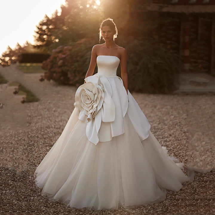 White strapless A-line bridal gown with large fabric flower rosette at the waist