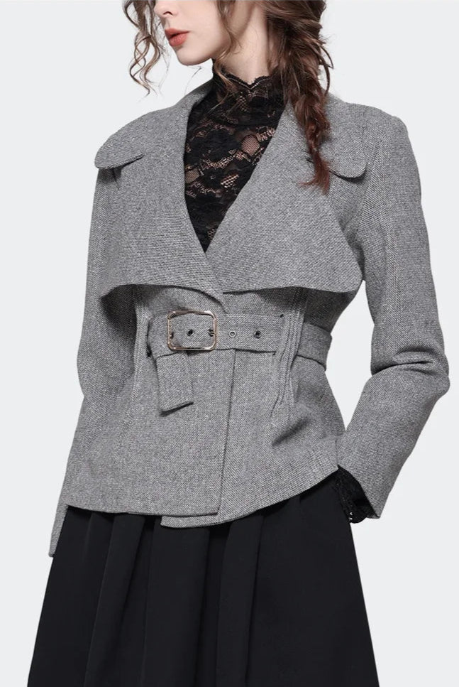 Woman wearing a gray coat with unique lapel design on a white background