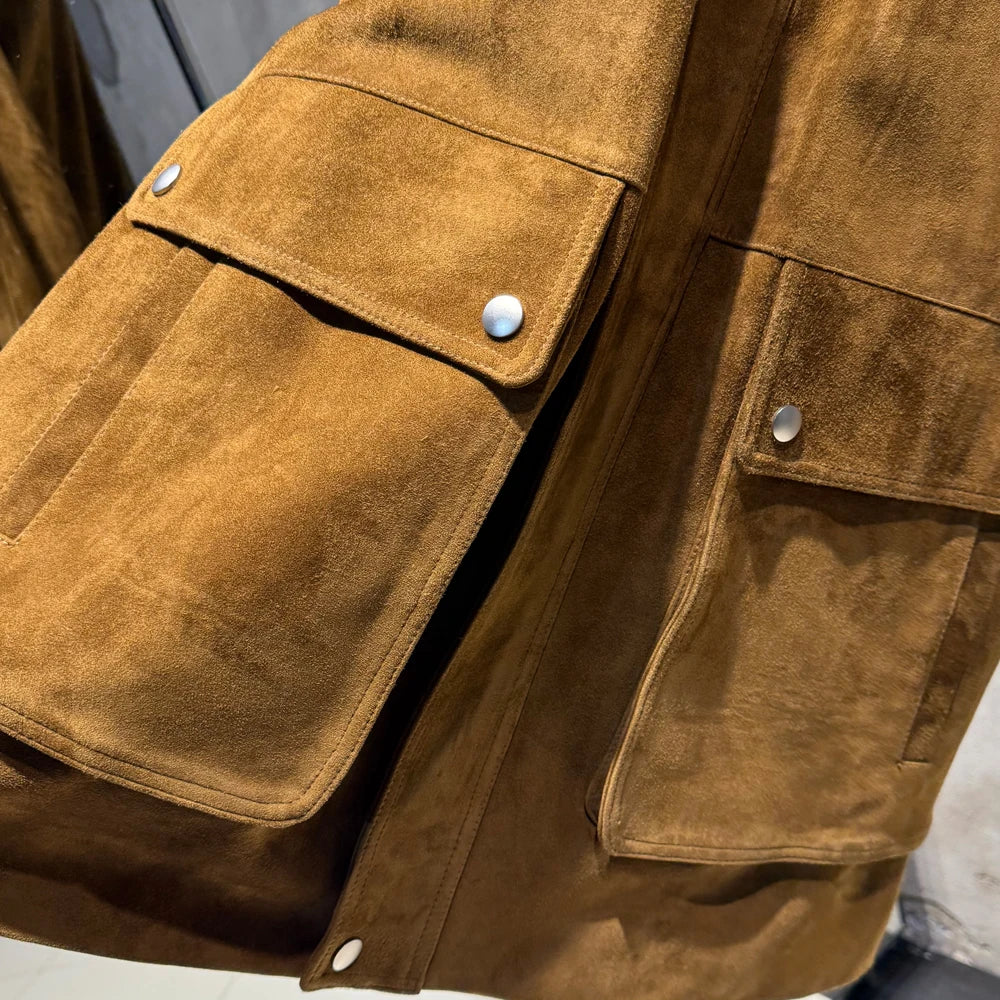 Golden-brown suede leather coat front with flap pockets, snap buttons, and contrast panel seams