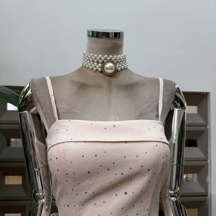 Beige polka dot mini dress on mannequin, pearl-look collar with round center clasp