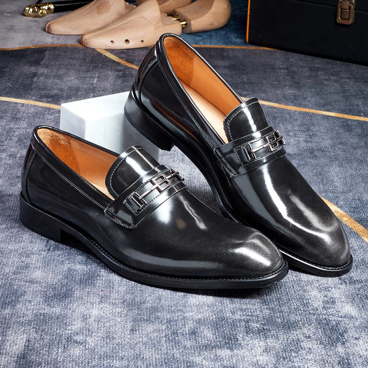 Black pointed toe leather loafers with buckle strap and tan lining