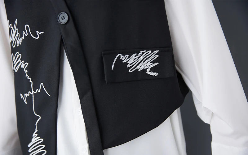 Black waistcoat close-up: embroidered pocket panel with buttoned placket