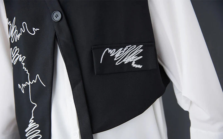 Black waistcoat close-up: embroidered pocket panel with buttoned placket