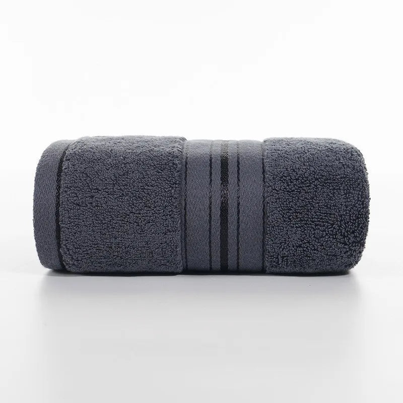 Dark gray face towel roll with stitched stripe bands and dense plush texture