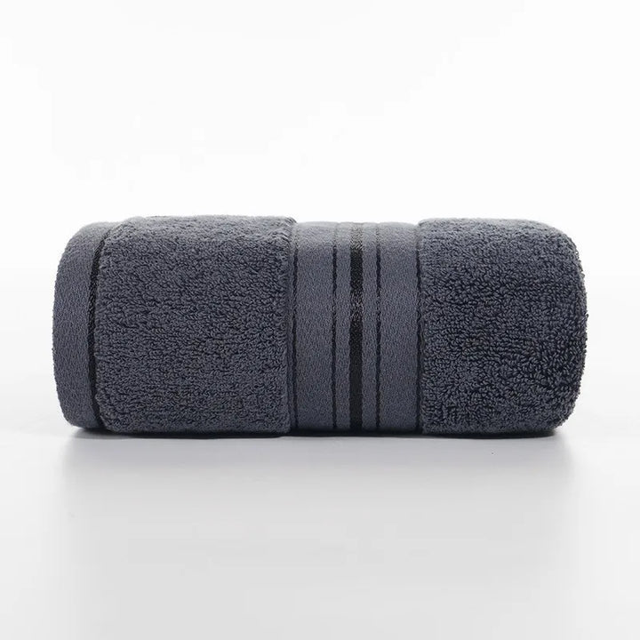 Dark gray face towel roll with stitched stripe bands and dense plush texture