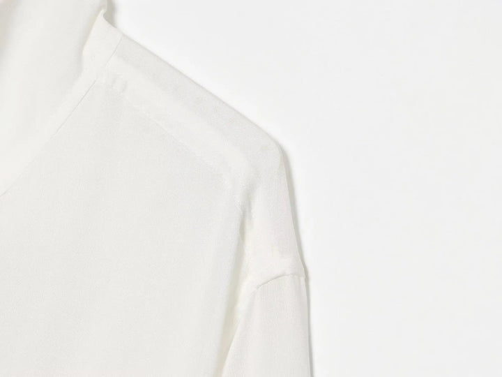 White stand-collar zip-up jacket, close-up shoulder seam and front panel