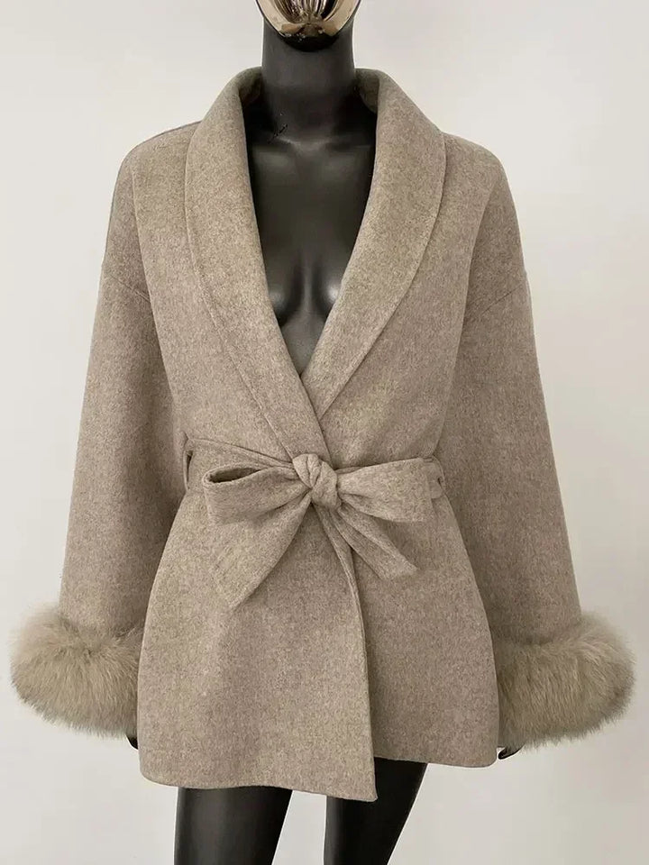 Cashmere-wool coat in beige with shawl lapels, tied waist belt, and faux fur trimmed cuffs
