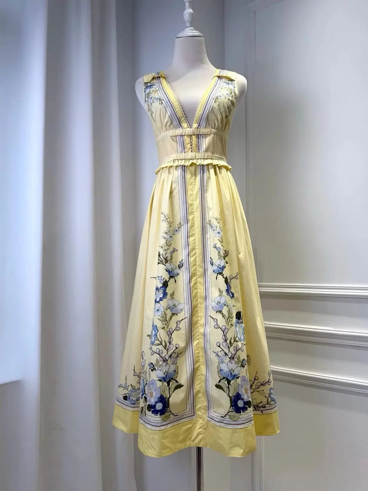 Light yellow floral midi dress on mannequin with sleeveless ruffled trim and vertical border