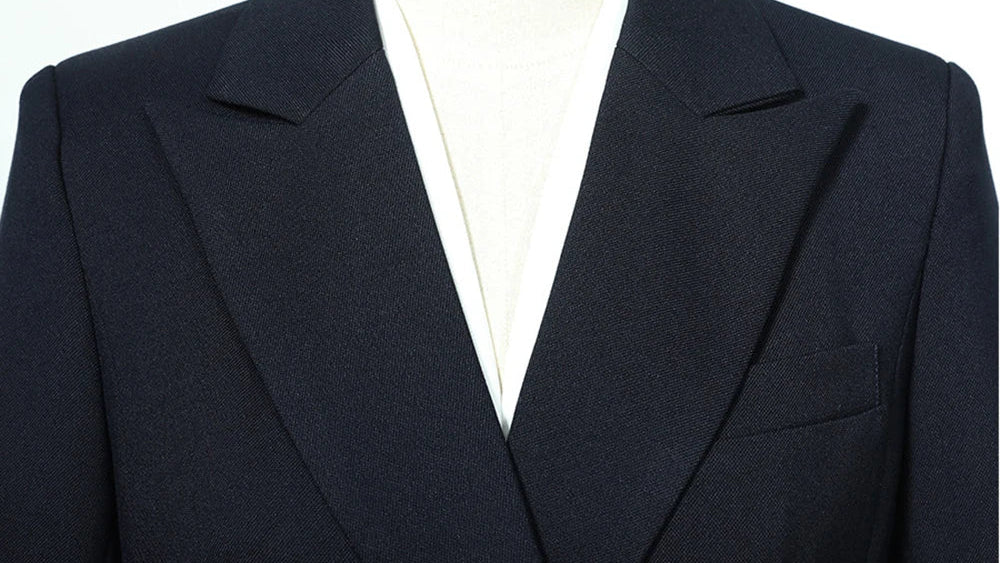 Navy blazer lapel and chest pocket framing with white V-neck lining