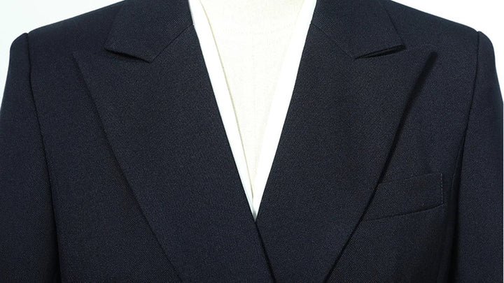 Navy blazer lapel and chest pocket framing with white V-neck lining