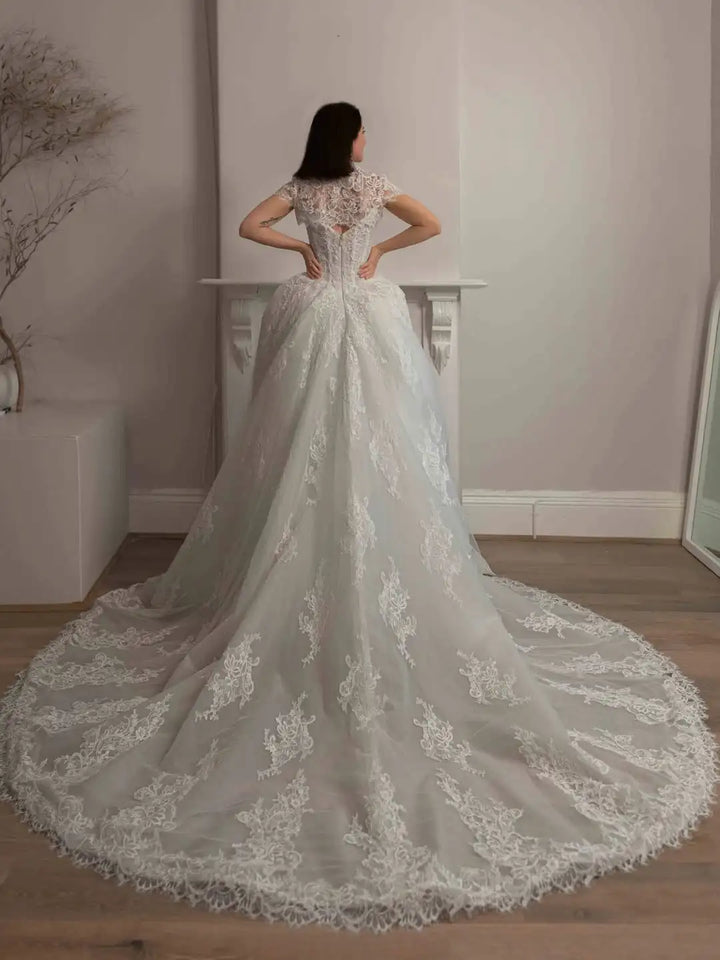 Ivory lace A-line bridal gown with lace corset back and sweeping train, back view
