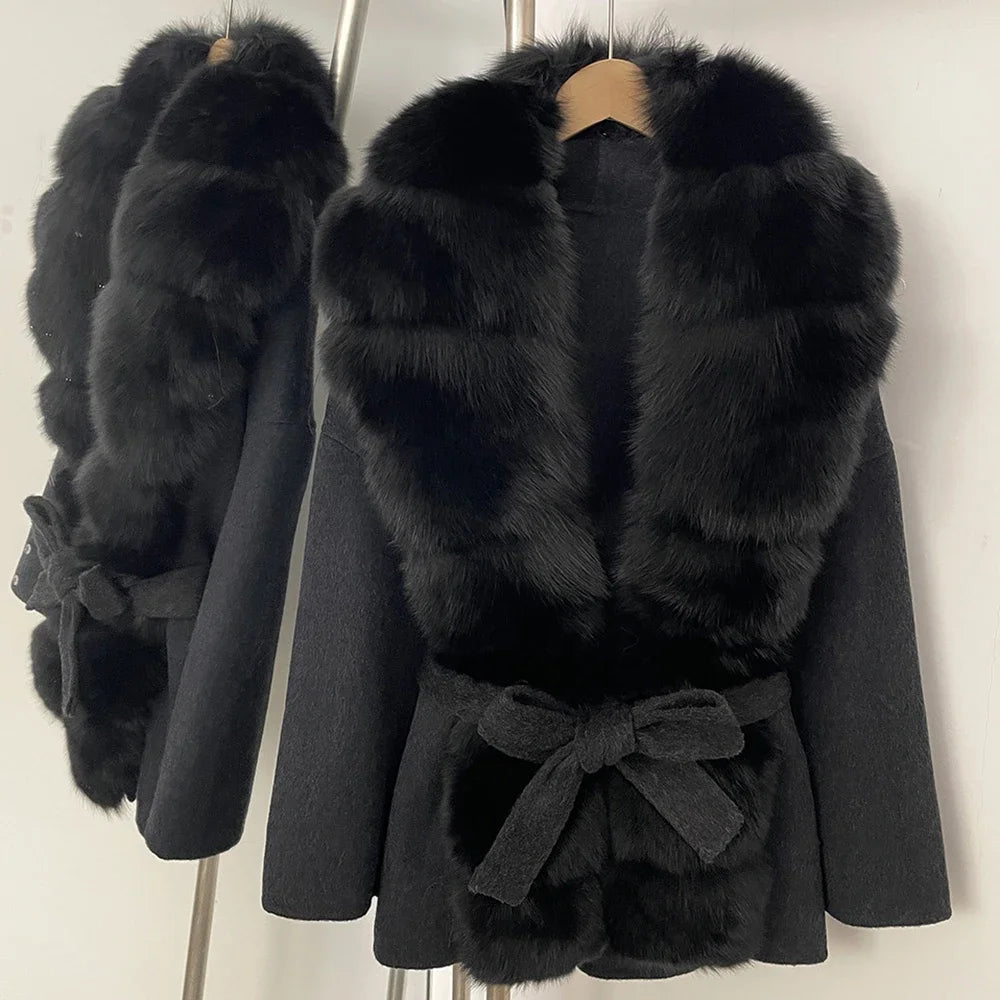 Black coat with faux fur front panels, wide lapels, and waist tie belt with fur cuffs