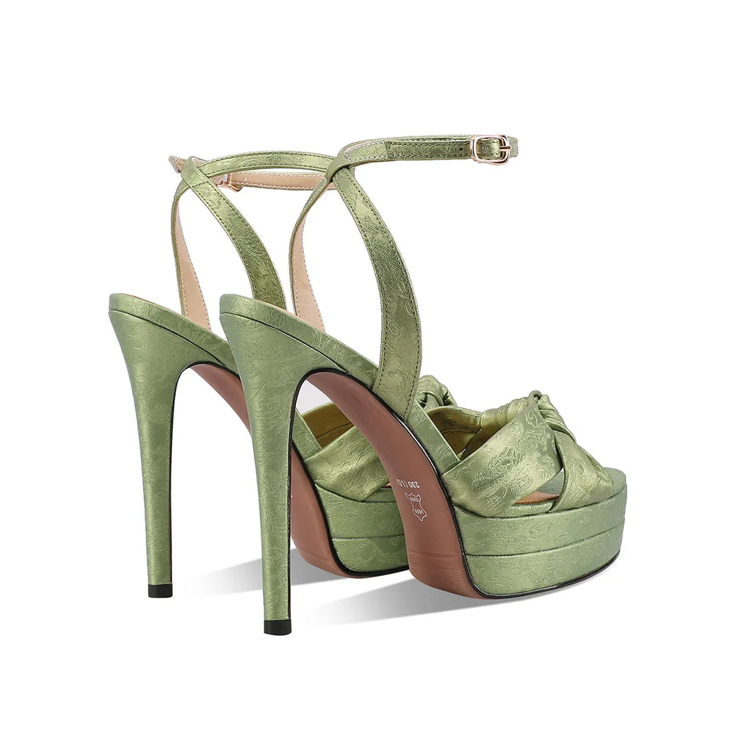Green leather high-heel platform sandals with ankle strap and bow across the toe