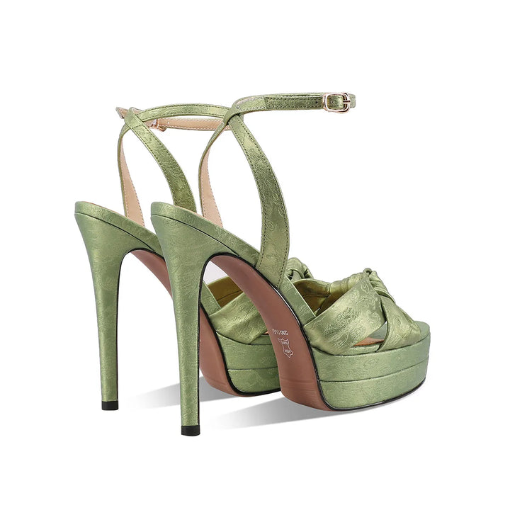 Green leather high-heel platform sandals with ankle strap and bow across the toe