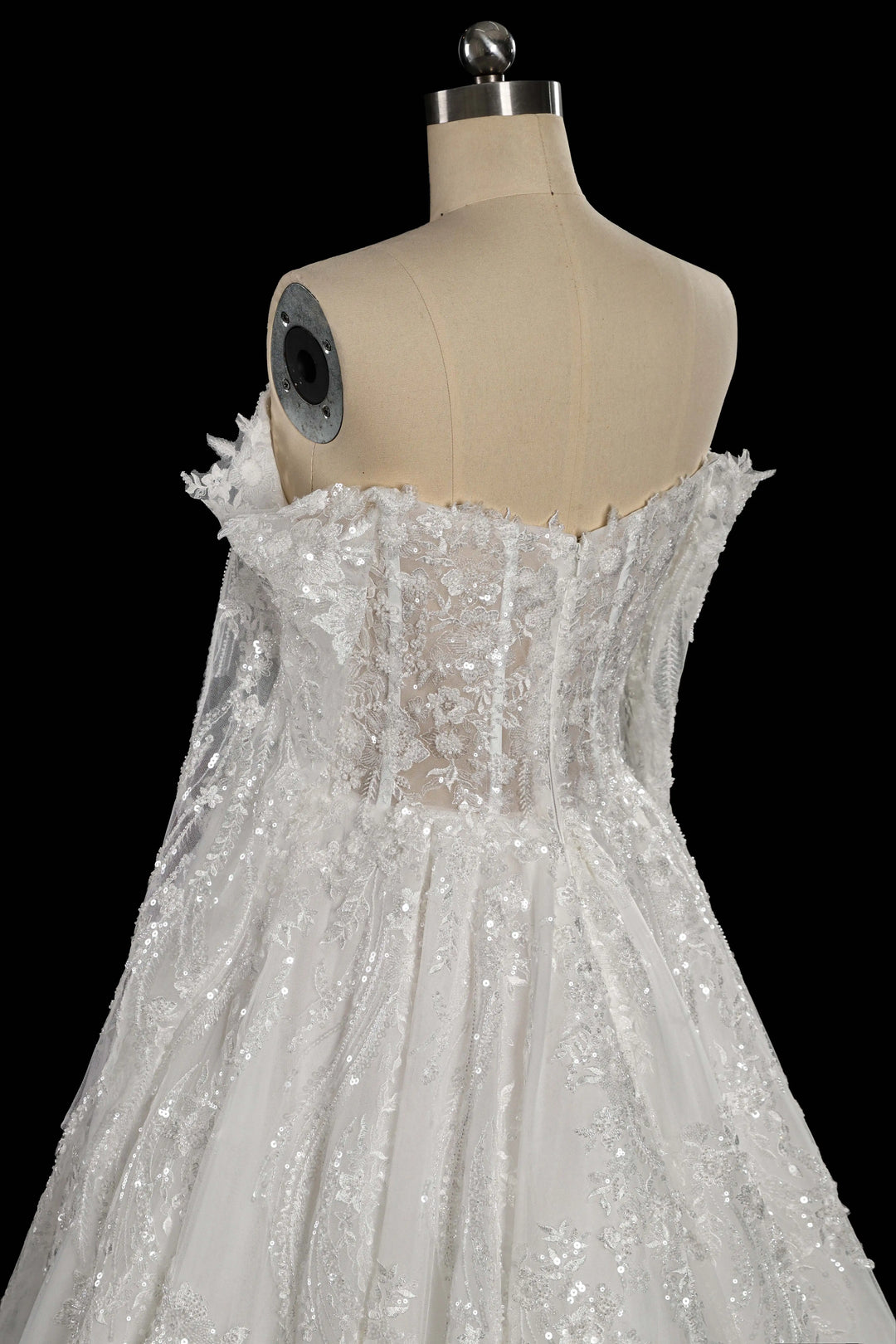 White sequin corset wedding gown with off-shoulder lace bodice, mannequin side view