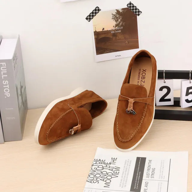 Brown suede slip-on loafers with metal buckle and moc toe stitching