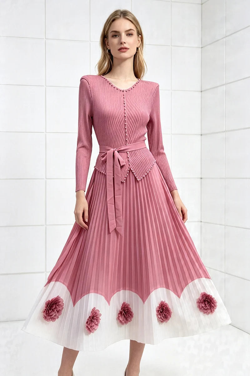 Pink pleated midi party dress with long sleeves, tied waist, scalloped pom hem with floral appliques.