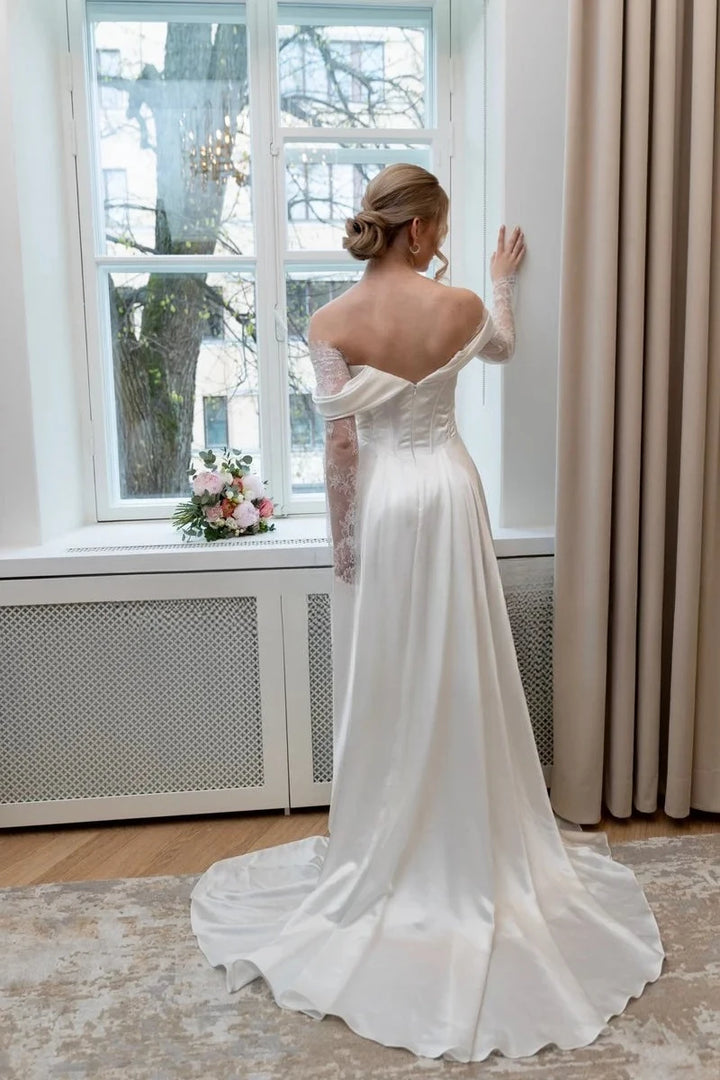 Ivory off-shoulder satin bridal gown with lace sleeves and draped A-line skirt with train