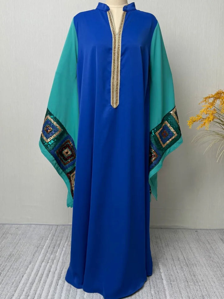 Blue abaya dress on mannequin, turquoise batwing sleeves, gold tassel placket detail