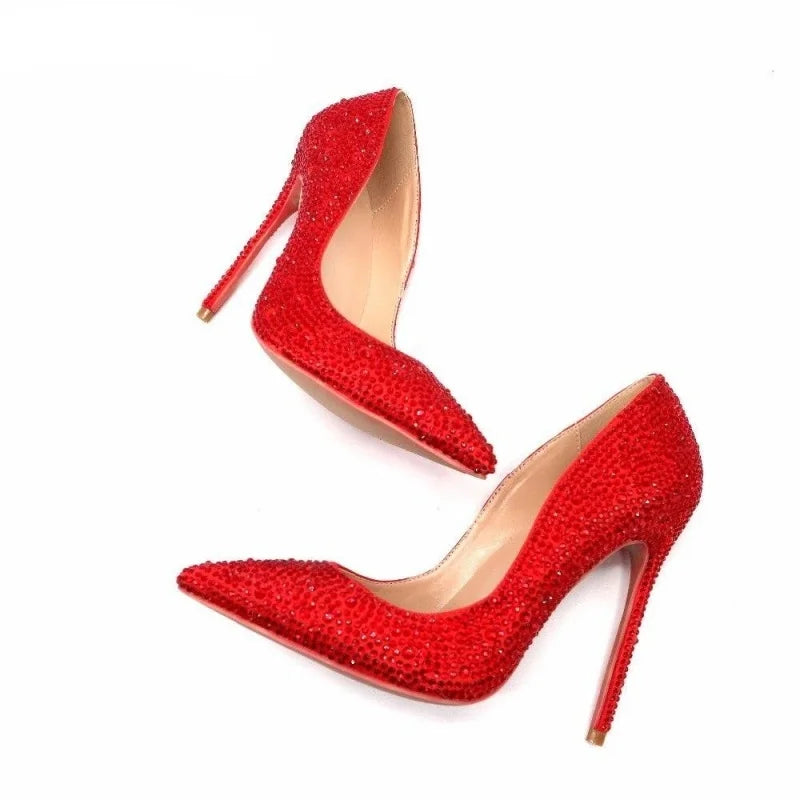 Red rhinestone pointed-toe high heel pumps, angled side pair with stiletto heels