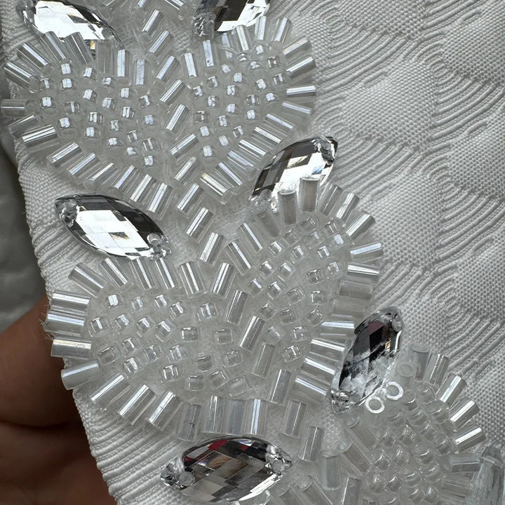 Close-up of a decorative silver mask with crystal-like embellishments.