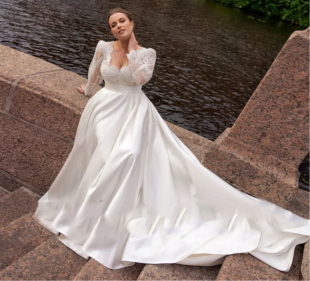 Woman in a white wedding dress standing by a water fountain