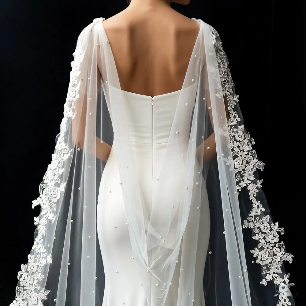 White sheer bridal cape with pearl-like beading and floral lace trim at edges