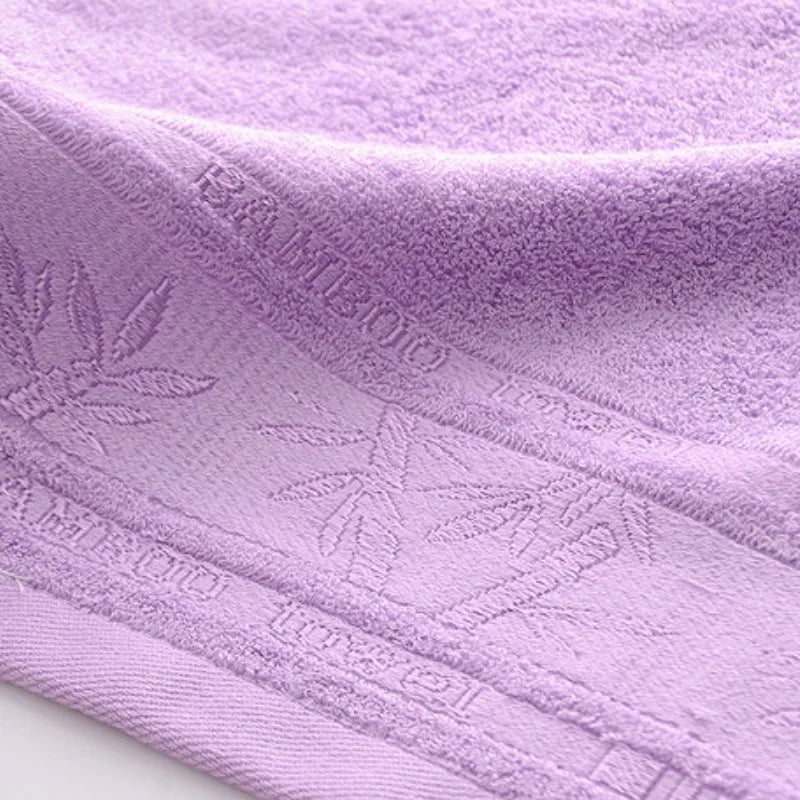 Lavender bamboo fiber hand towel close-up with leaf-patterned border and stitched edge