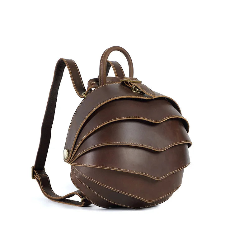 Dark brown leather backpack with curved flap, brass-tone buckle, crossbody strap
