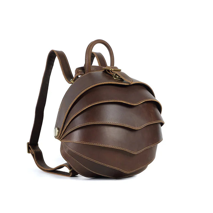 Dark brown leather backpack with curved flap, brass-tone buckle, crossbody strap