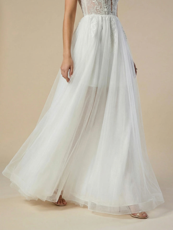 White tulle wedding dress with voluminous skirt and sheer overlay train