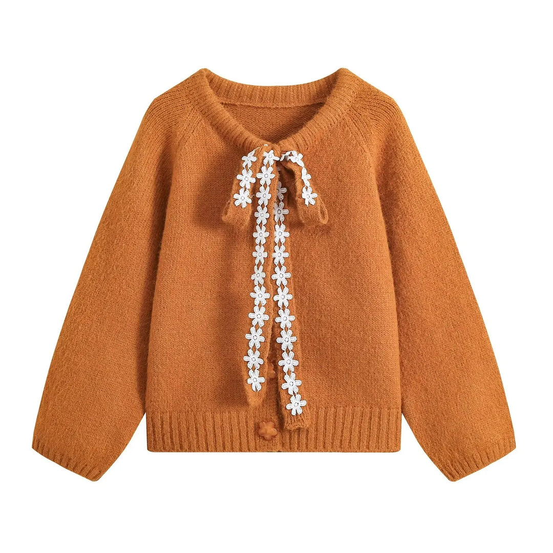 Orange cropped knit cardigan with lace-up tie and floral trim