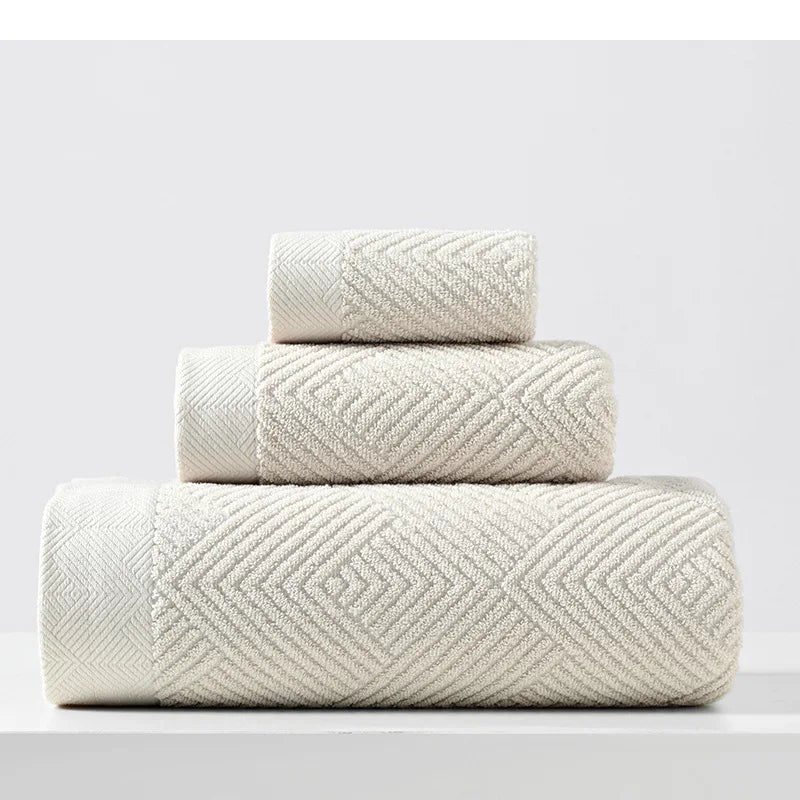 Beige cotton towel set with thick chevron weave, stacked folded towels