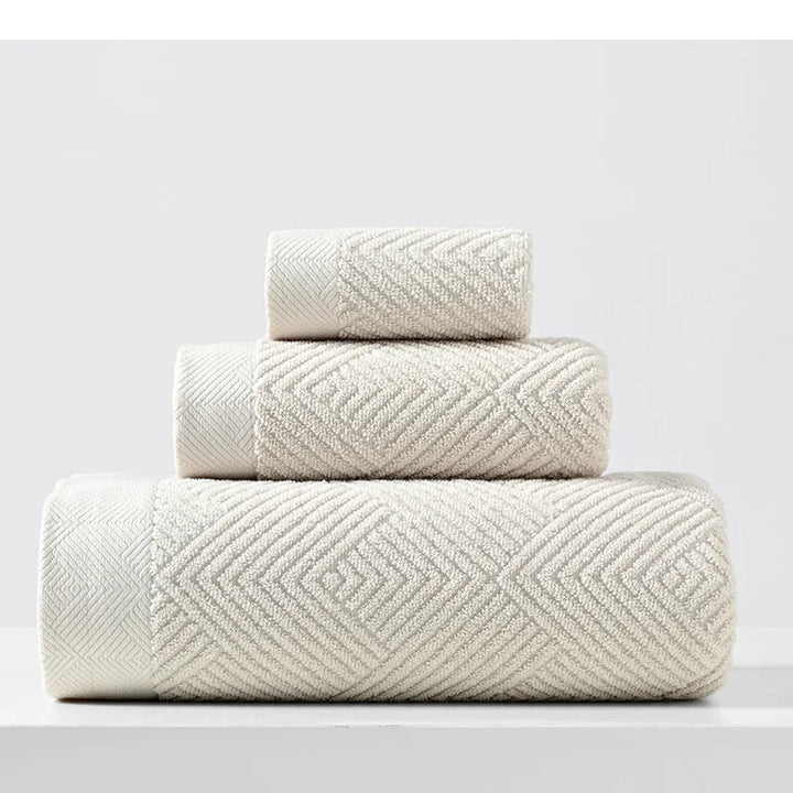 Beige cotton towel set with thick chevron weave, stacked folded towels
