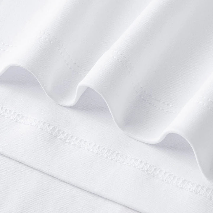 White crew-neck tee fabric close-up with stitched hem and seam details