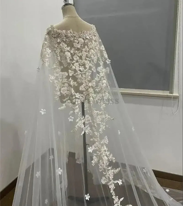 Lace wedding dress with floral embellishments on a mannequin against a plain background