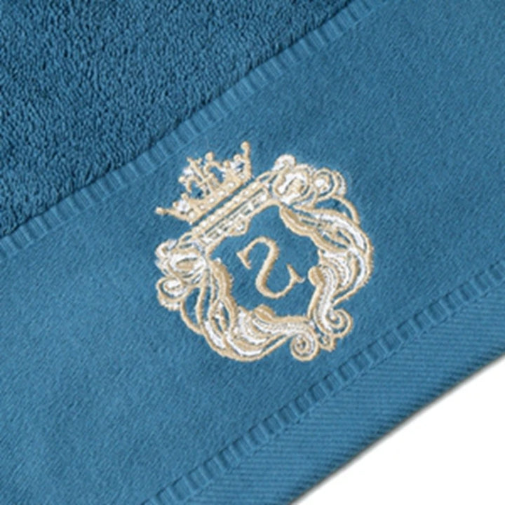 Blue cotton bath towel corner with gold embroidered crest and stitched border