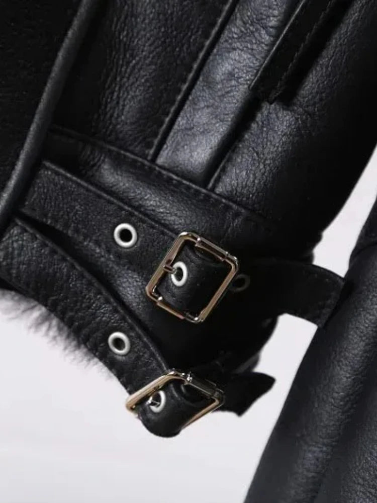 Black leather jacket cuff with snap strap, buckle hardware, and grommet accents