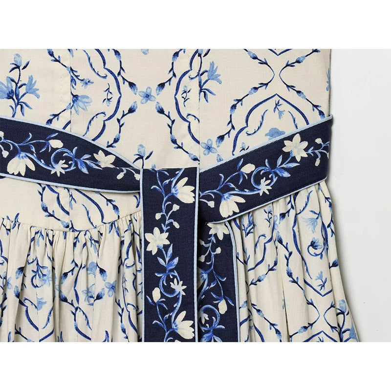 Cami dress bodice with wide navy sash belt and blue flower print, light background