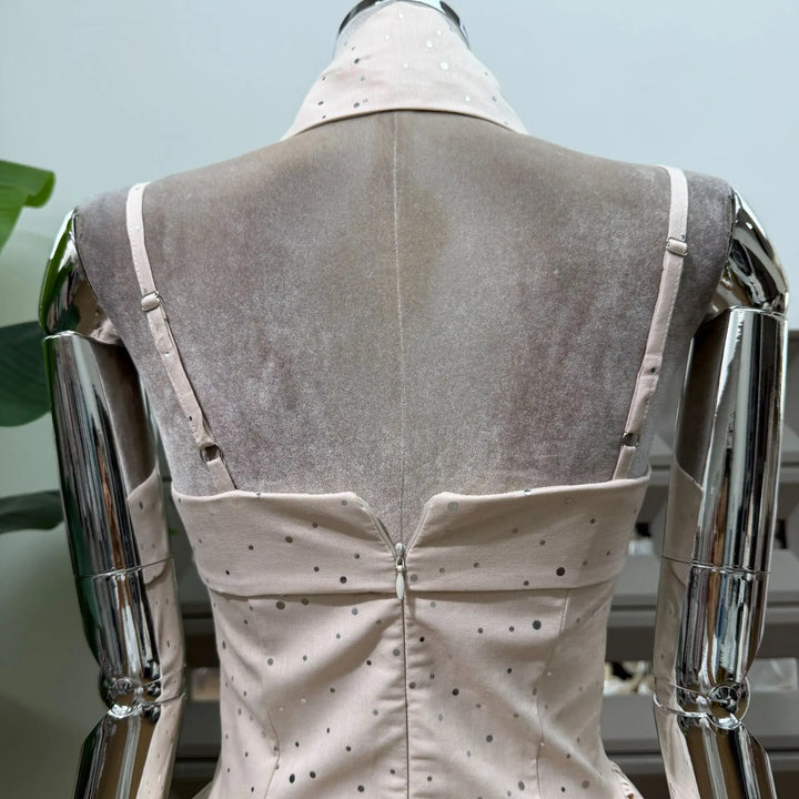 Beige polka dot mini dress on mannequin, back corset seams and buttoned waist