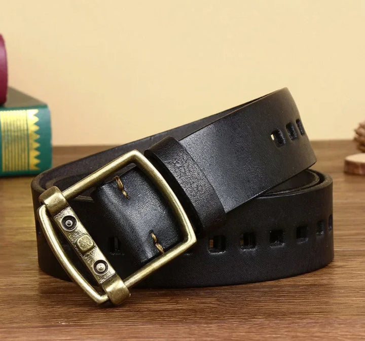 Black leather belt with a gold buckle on a wooden surface
