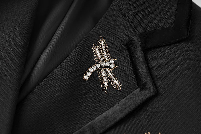 Black blazer chest area with textured pocket and cross rhinestone embellishment