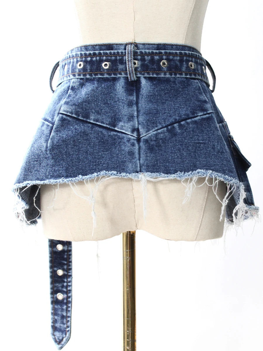Close-up of blue denim spliced hem with frayed edges and metal-stud belt tabs